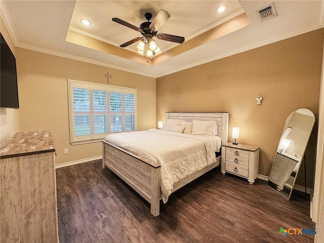 bedroom featuring a raised ceiling, ornamental molding, dark hardwood / wood-style floors, and ceiling fan