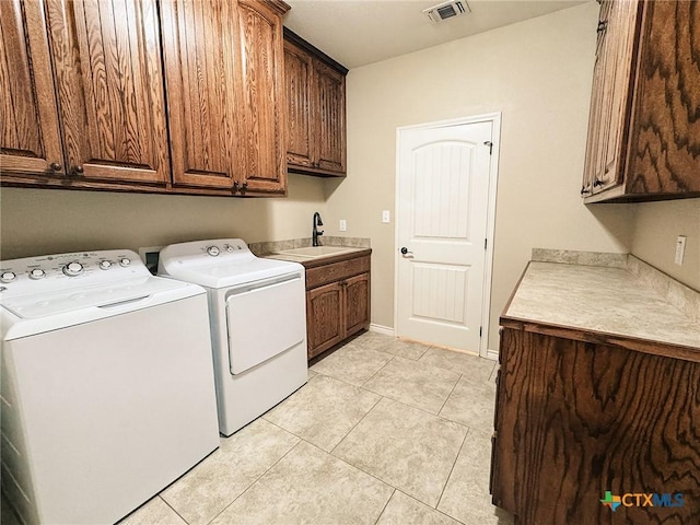 laundry area featuring cabinets, sink, light tile patterned floors, and independent washer and dryer