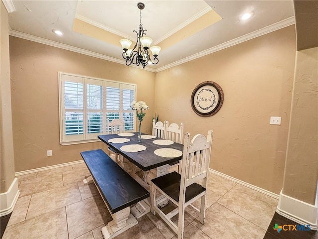 dining area with a notable chandelier, a tray ceiling, and ornamental molding