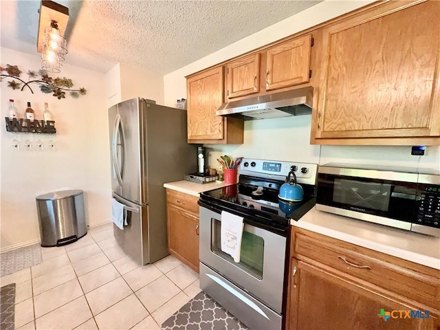 403 Suzie St, Killeen, TX 76542 - kitchen with appliances with stainless steel finishes, under cabinet range hood, light tile patterned floors, light countertops, and a textured ceiling