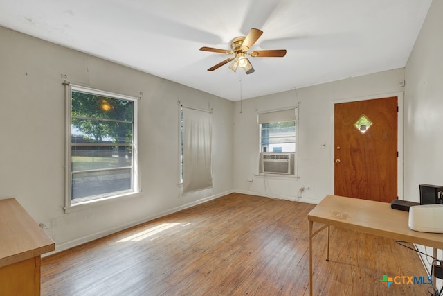 foyer entrance with light wood-type flooring, cooling unit, and ceiling fan