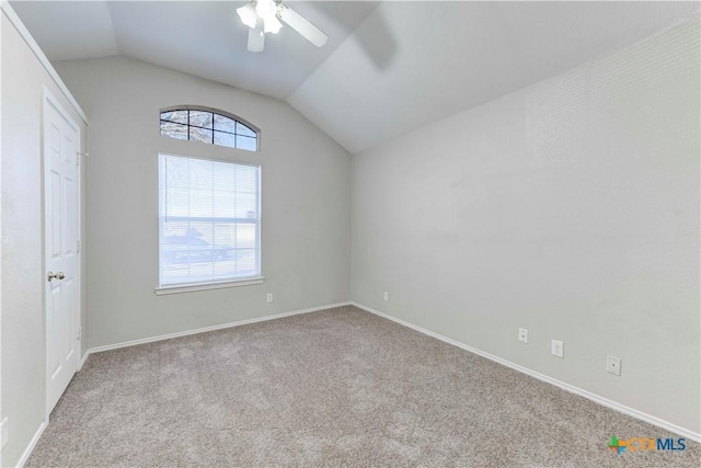 carpeted spare room with a wealth of natural light, lofted ceiling, and ceiling fan