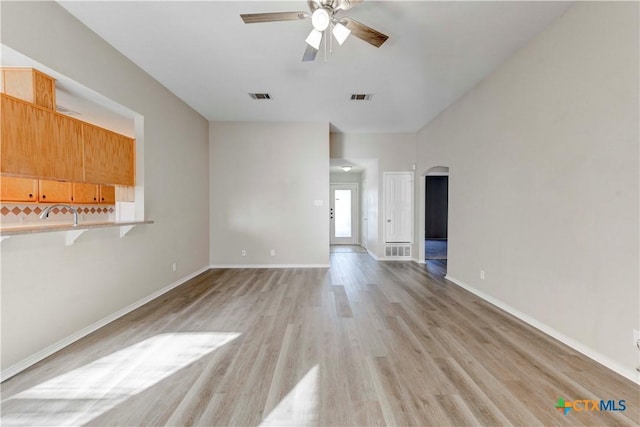 unfurnished living room featuring ceiling fan and light hardwood / wood-style flooring