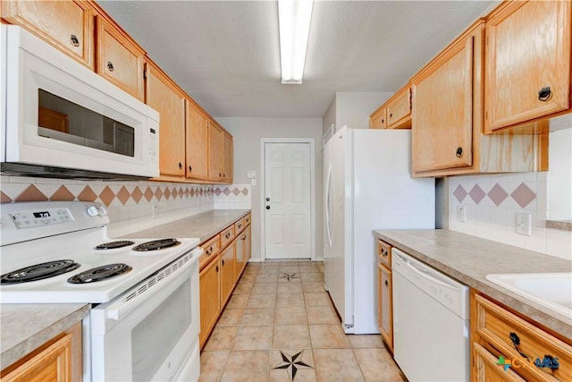 kitchen featuring white appliances, backsplash, and light tile patterned floors