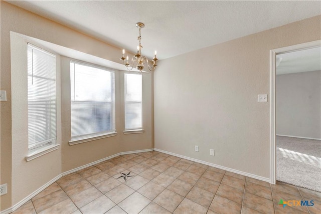 tiled empty room with a chandelier