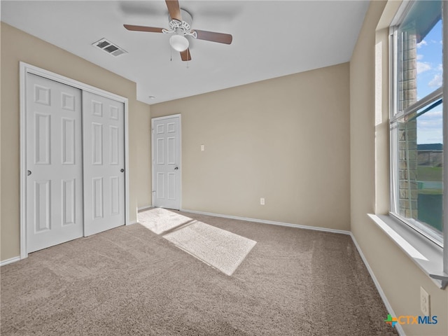 unfurnished bedroom with ceiling fan, a closet, and carpet