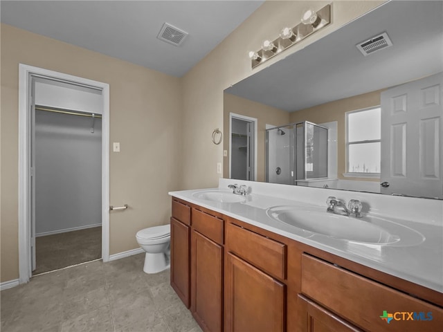 bathroom with vanity, toilet, and a shower with shower door