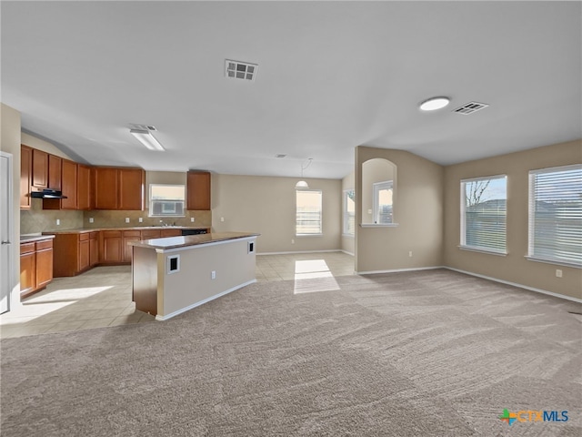 kitchen featuring a kitchen island, pendant lighting, light carpet, and decorative backsplash