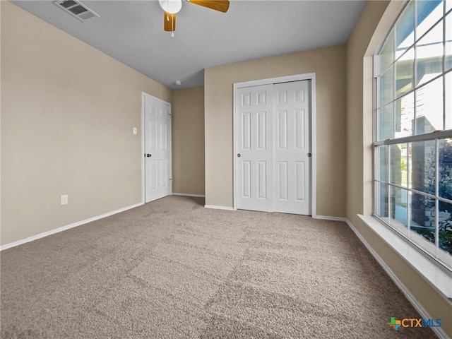 unfurnished bedroom featuring carpet floors, ceiling fan, and a closet