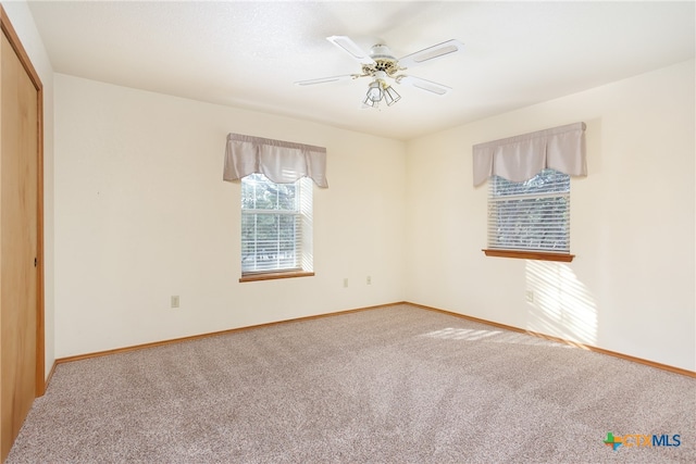 empty room with ceiling fan and carpet