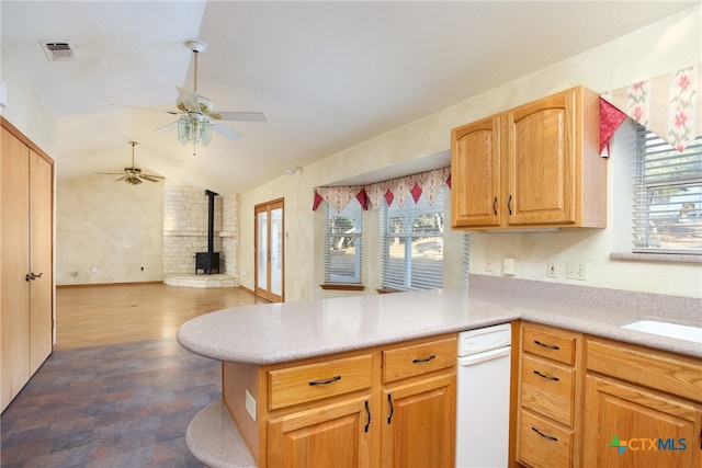 kitchen with vaulted ceiling, a wood stove, kitchen peninsula, dark hardwood / wood-style floors, and ceiling fan