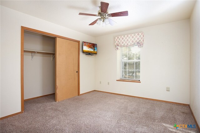 unfurnished bedroom featuring a closet, carpet flooring, and ceiling fan