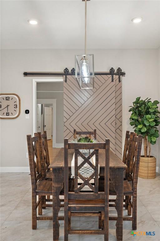 dining space featuring baseboards, recessed lighting, and a barn door