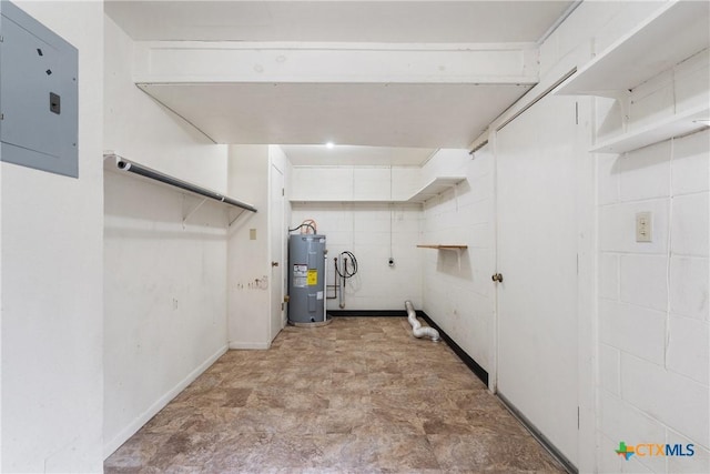 below grade area featuring electric panel, water heater, and concrete block wall