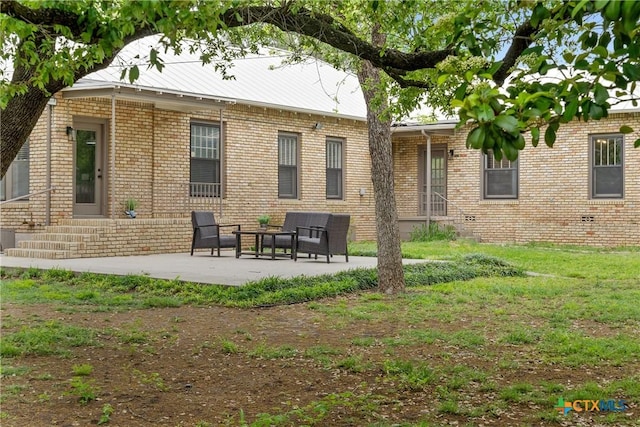 back of house with a patio area and brick siding