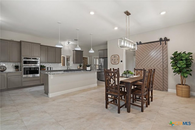 dining room featuring recessed lighting, baseboards, and a barn door