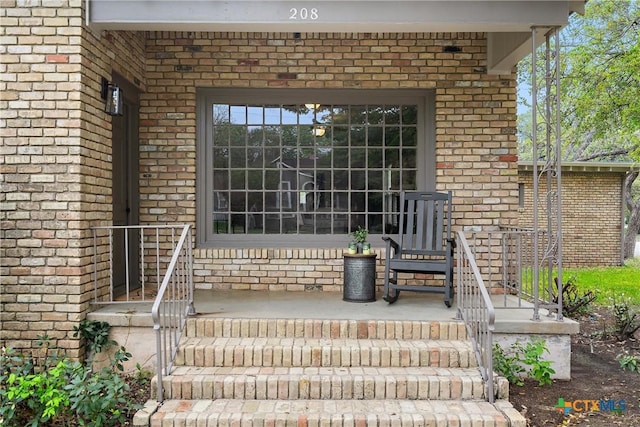view of exterior entry with brick siding