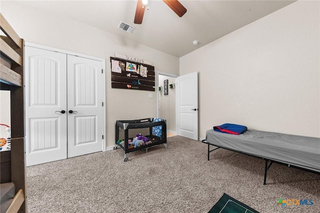 carpeted bedroom featuring ceiling fan, visible vents, and a closet
