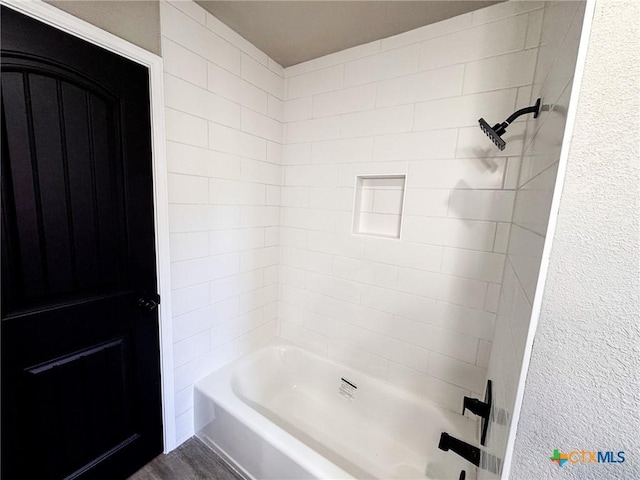 bathroom featuring hardwood / wood-style flooring and tiled shower / bath