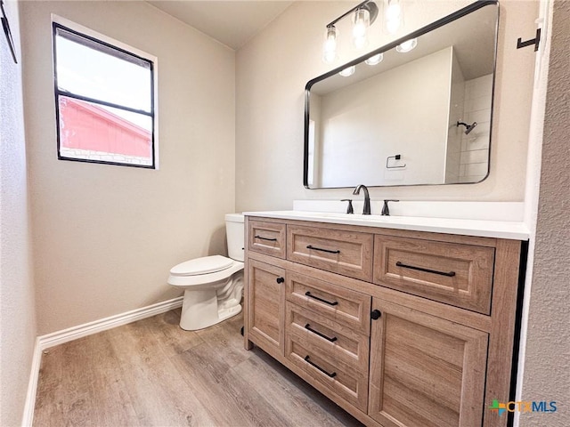 bathroom with wood-type flooring, toilet, and vanity