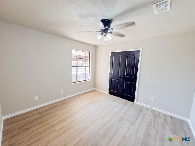 unfurnished bedroom with a textured ceiling, light hardwood / wood-style flooring, and ceiling fan