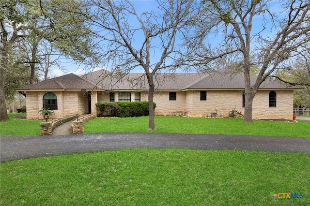 ranch-style home with a front lawn