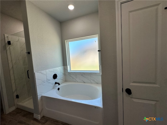 bathroom with hardwood / wood-style flooring and independent shower and bath