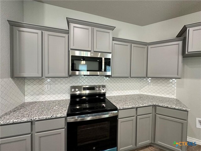 kitchen with black electric range, dark wood-type flooring, sink, and a center island with sink