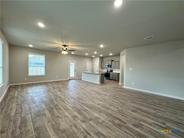 3110 Gryffindor Ln, Killeen, TX 76549 - unfurnished living room featuring a ceiling fan, dark wood-style floors, baseboards, recessed lighting, and a sink