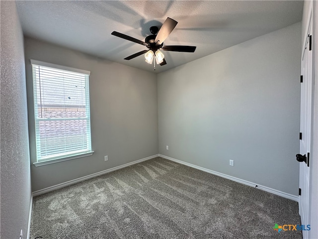 carpeted spare room featuring a textured ceiling and ceiling fan