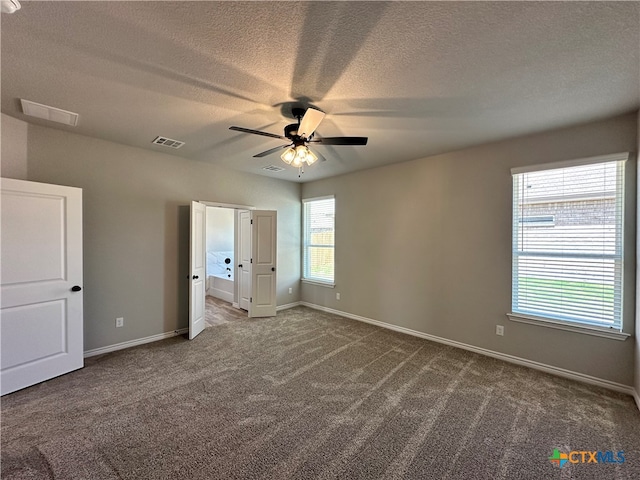 carpeted spare room featuring ceiling fan and a textured ceiling