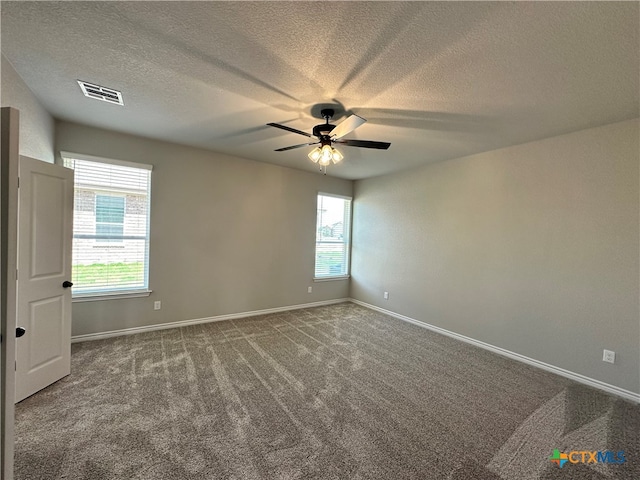 carpeted spare room featuring ceiling fan and a textured ceiling