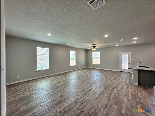 interior space featuring ceiling fan, a textured ceiling, dark hardwood / wood-style floors, and plenty of natural light