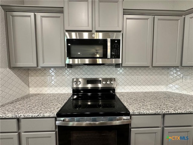 3110 Gryffindor Ln, Killeen, TX 76549 - kitchen featuring appliances with stainless steel finishes, gray cabinets, tasteful backsplash, and light stone counters