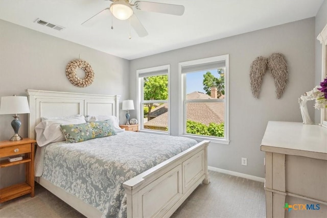 bedroom with baseboards, visible vents, a ceiling fan, and light colored carpet
