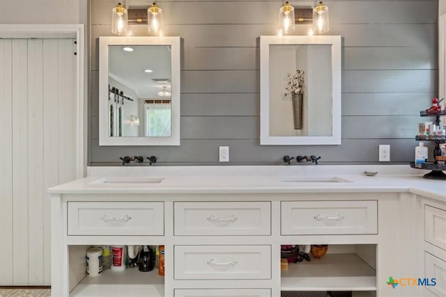 bathroom with wood walls, a sink, and double vanity