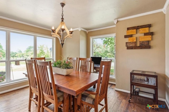 dining area featuring hardwood / wood-style flooring, baseboards, an inviting chandelier, and ornamental molding