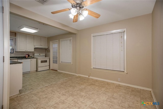 kitchen with ceiling fan, dark countertops, white appliances, baseboards, and under cabinet range hood