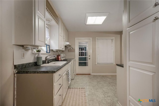 kitchen with dark countertops, a sink, range with electric cooktop, baseboards, and under cabinet range hood