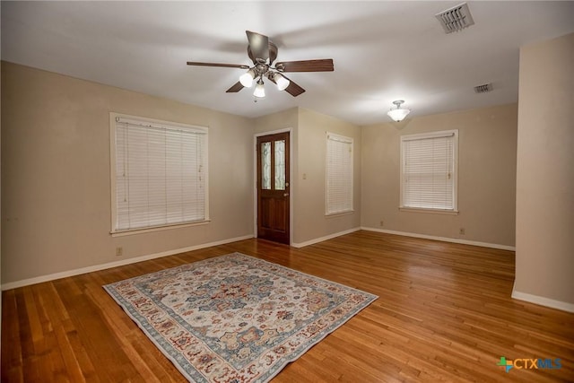 entryway featuring visible vents, light wood finished floors, ceiling fan, and baseboards