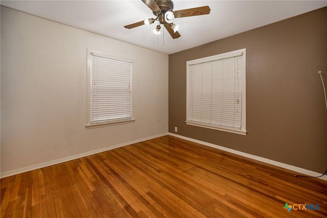 spare room with baseboards, ceiling fan, and wood finished floors