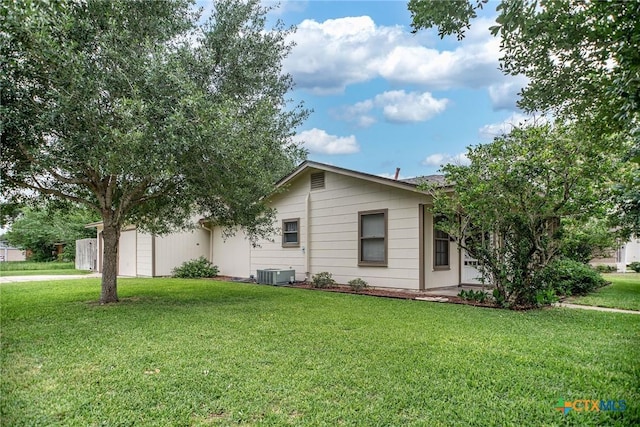 view of front facade featuring central AC, a garage, and a front lawn