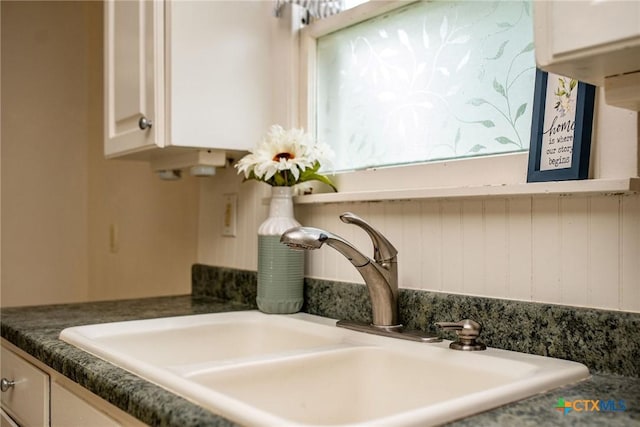 room details featuring a sink and white cabinetry