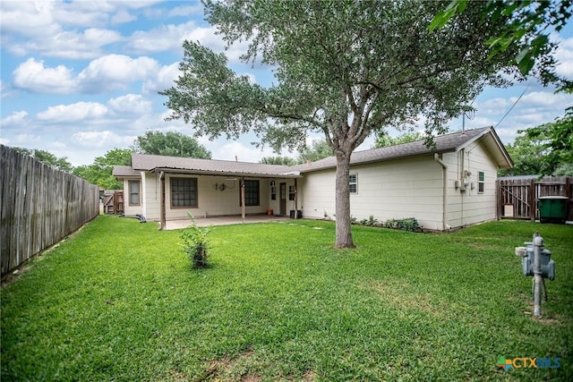 back of property with a yard, a patio, and a fenced backyard