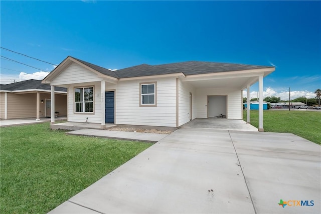ranch-style house featuring roof with shingles, a carport, driveway, and a front yard