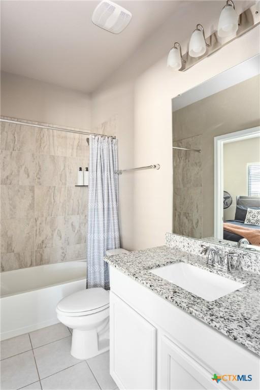 full bathroom featuring tile patterned floors, shower / bath combo with shower curtain, vanity, and toilet