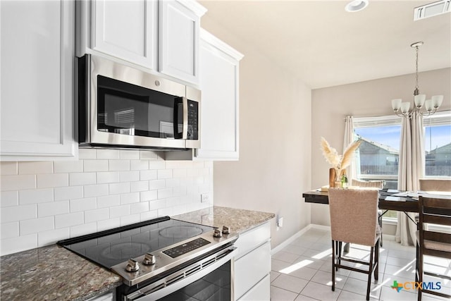 kitchen featuring stone counters, appliances with stainless steel finishes, tasteful backsplash, white cabinetry, and a chandelier