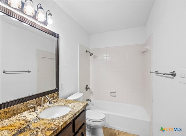 full bathroom with tile patterned flooring, tiled shower / bath, vanity, and toilet