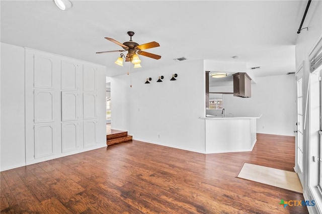 unfurnished living room featuring sink, wood-type flooring, and ceiling fan