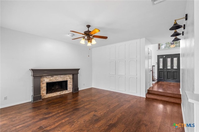 unfurnished living room with dark hardwood / wood-style flooring, a fireplace, and ceiling fan